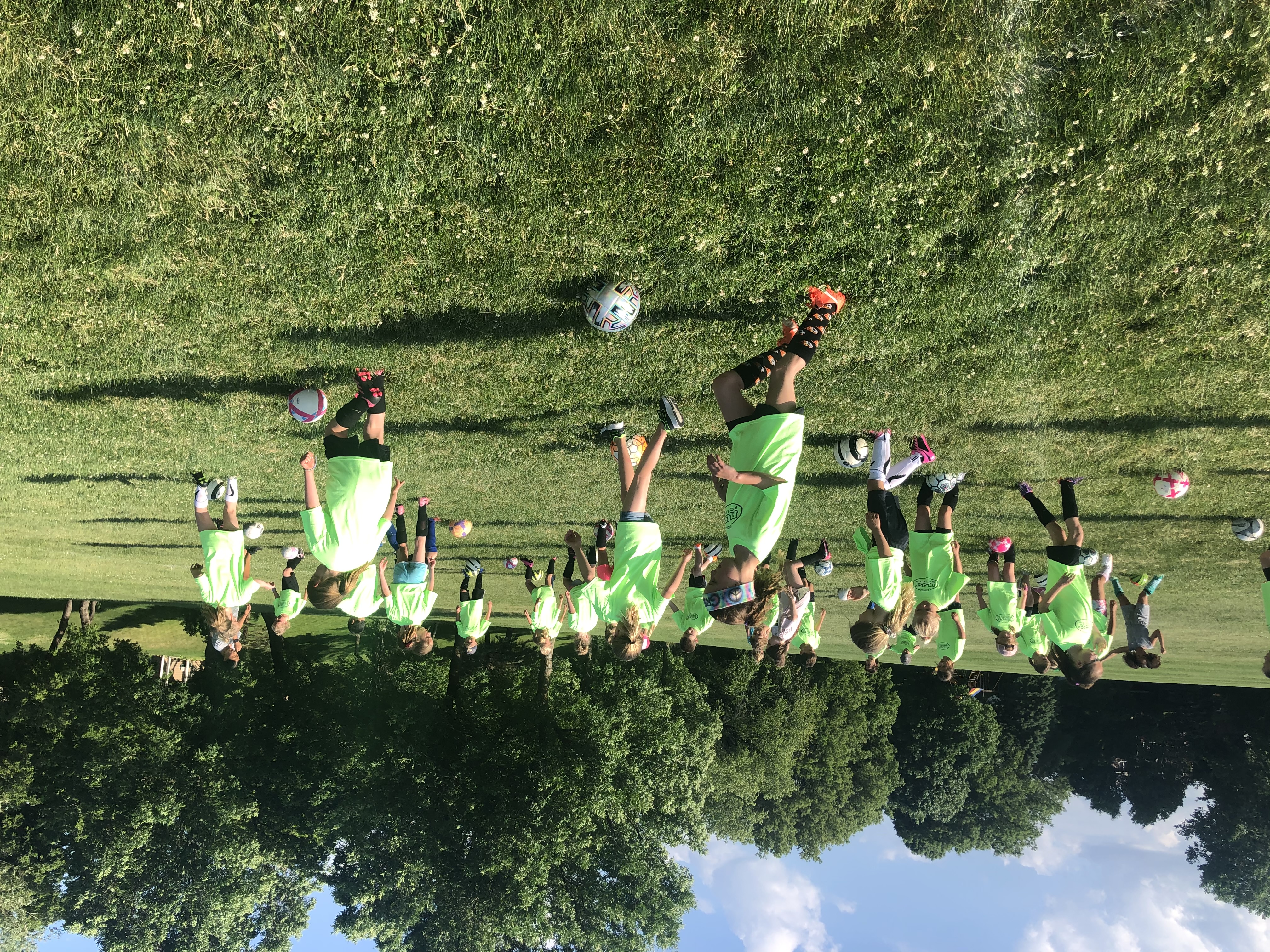Children playing soccer on a grass field